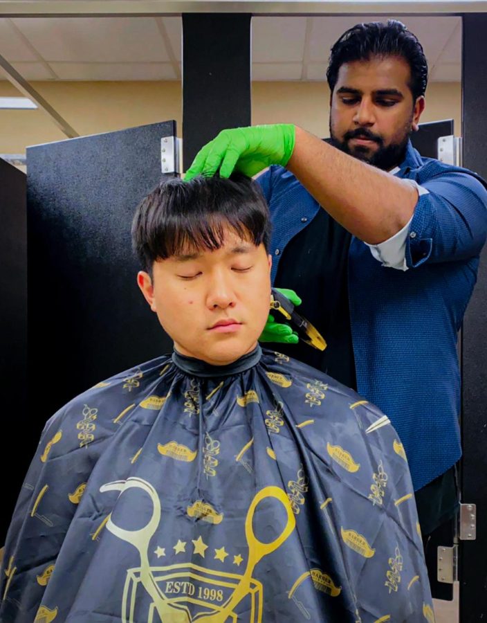 Calvin Selvin cutting Gwan Jae’s hair in their dorm bathroom. 