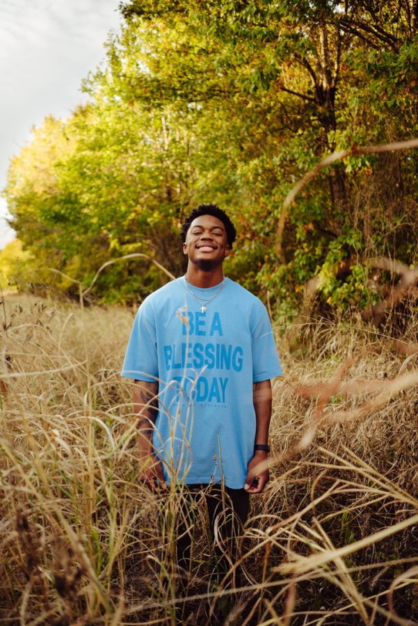 Graphic design freshman models a T-shirt from his own fashion brand, Wave of Blessings. 