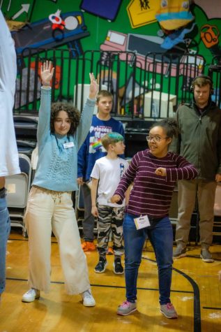 ORU freshman Ellie Ransdell, left, with arms raised, sings and dances with her Penguin Project students at Tulsa’s Clark Youth Center.