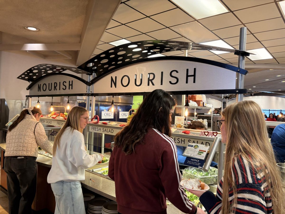 Oral Roberts University students line up at the Nourish station in Saga to fix salads.